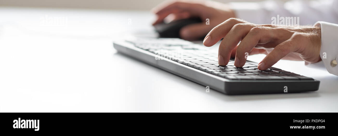 Wide view image of businessman using office computer keyboard. Stock Photo