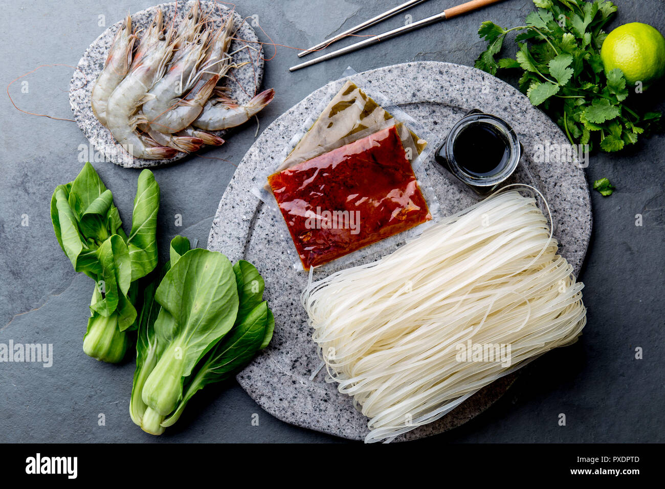 Asian cooking ingredients rice noodles, pok choy, sauces, raw shrimps