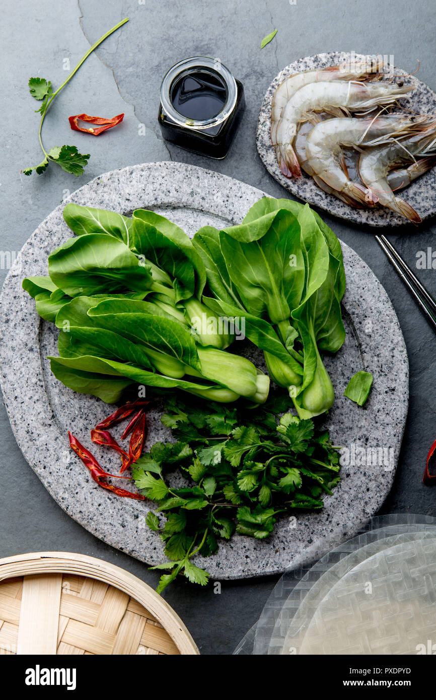 Asian cooking ingredients rice papper, pok choy, sauces, raw shrimps