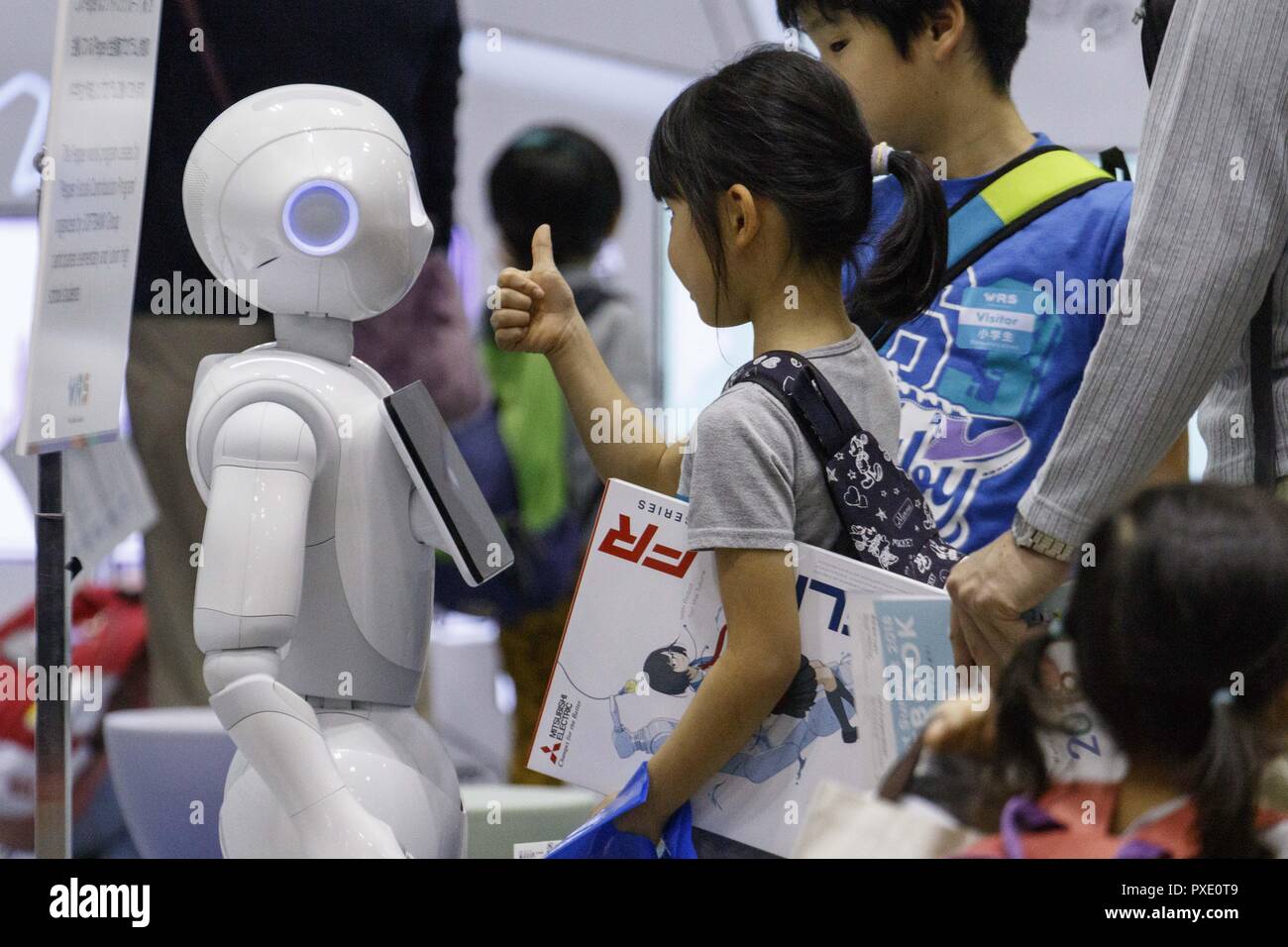 Tokyo, Japan. 21st Oct, A girl greets a humanoid robot Pepper during the World Robot 2018 in Tokyo Big Sight. The showcases the latest technology robots in fields like