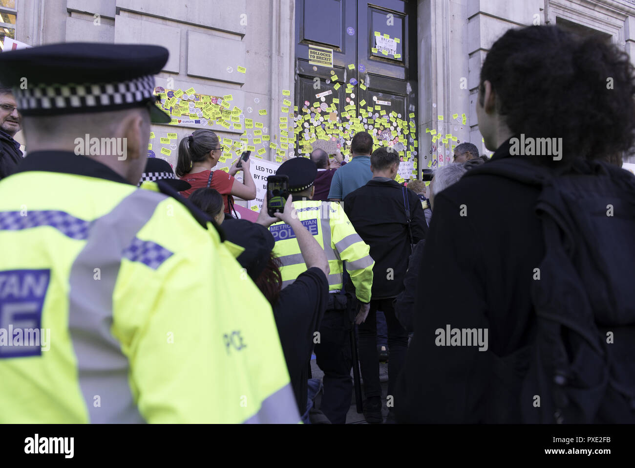 London, Greater London, UK. 20th Oct, 2018. Police officers are seen walking to the Cabinet office building entrance to prevent anti-Brexit protesters from continuing to stick their stickers around the entrance during the march.A huge demonstration organised by the People's vote campaign gathered at Park Lane to march to the Parliament Square to protest against the Tory government's Brexit negotiations and demanding for a second vote on the final Brexit deal. Credit: Andres Pantoja/SOPA Images/ZUMA Wire/Alamy Live News Stock Photo