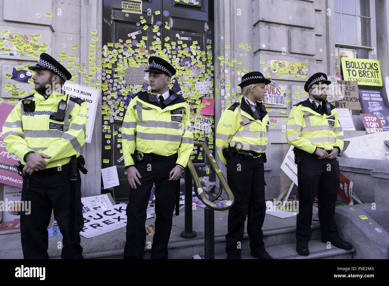 London, Greater London, UK. 20th Oct, 2018. Police officers are seen standing on guard in the Cabinet office building entrance to prevent anti-Brexit protesters from continuing sticking stickers around the entrance during the march.A huge demonstration organised by the People's vote campaign gathered at Park Lane to march to the Parliament Square to protest against the Tory government's Brexit negotiations and demanding for a second vote on the final Brexit deal. Credit: Andres Pantoja/SOPA Images/ZUMA Wire/Alamy Live News Stock Photo