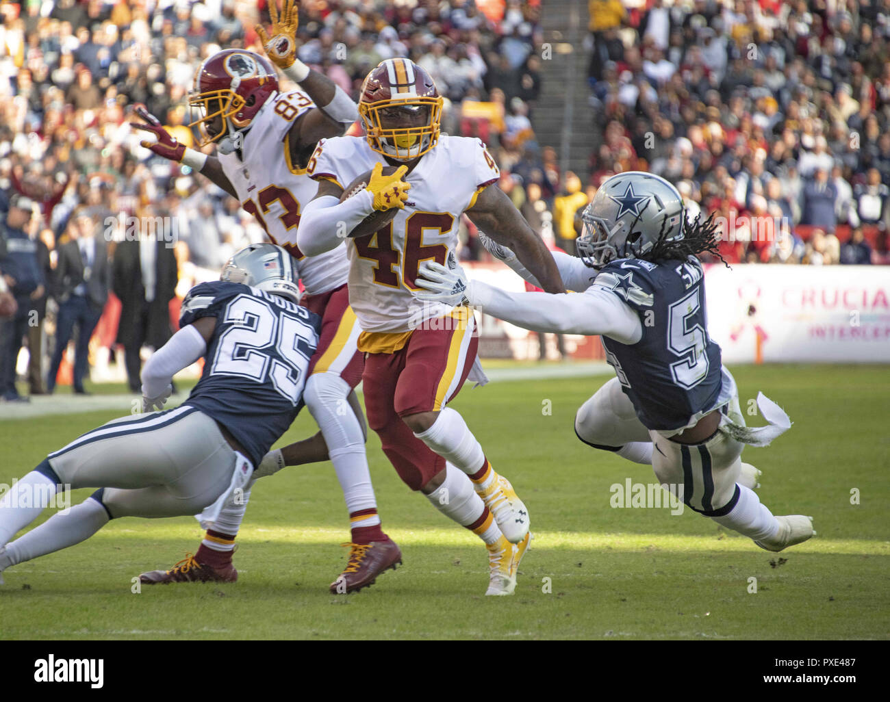Landover, Maryland, USA. 21st Oct, 2018. Washington Redskins running back Kapri Bibbs (46) eludes an attempted tackle by Dallas Cowboys linebacker Jaylon Smith (54) as he runs for a touchdown in the first quarter at FedEx Field in Landover, Maryland on Sunday, October 21, 2018 Credit: Ron Sachs/CNP/ZUMA Wire/Alamy Live News Stock Photo
