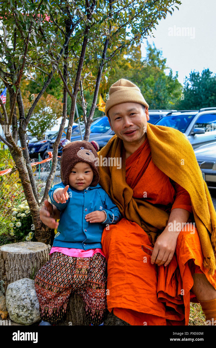 A chilly Thai Buddhist monk and child celebrated the End Of Lent at the Wat Boston Buddha Vararam Temple. It's one of only two Buddhist temples in Massachusetts, USA. Stock Photo