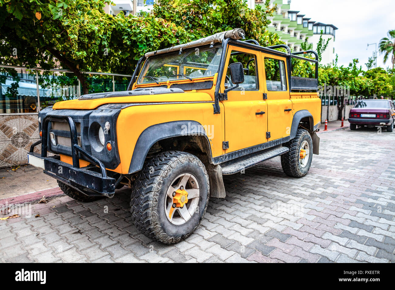 Yellow offroad vehicle stands on a street Stock Photo
