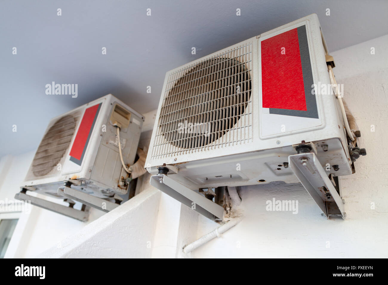 Two air conditioner hangs on a white wall Stock Photo