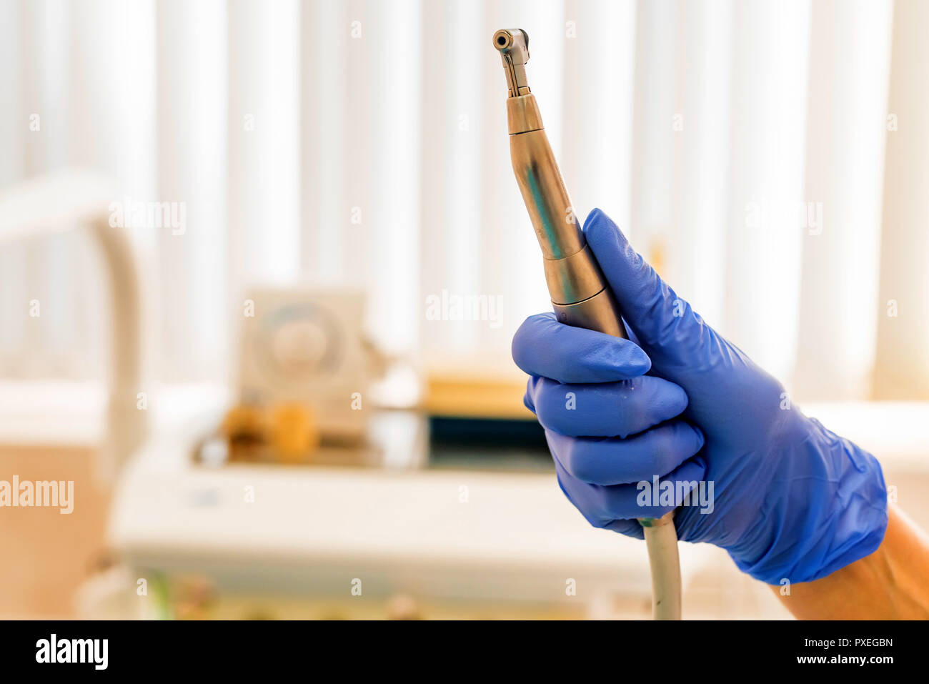 Hand of dentist in glove holds dental drill machine Stock Photo - Alamy