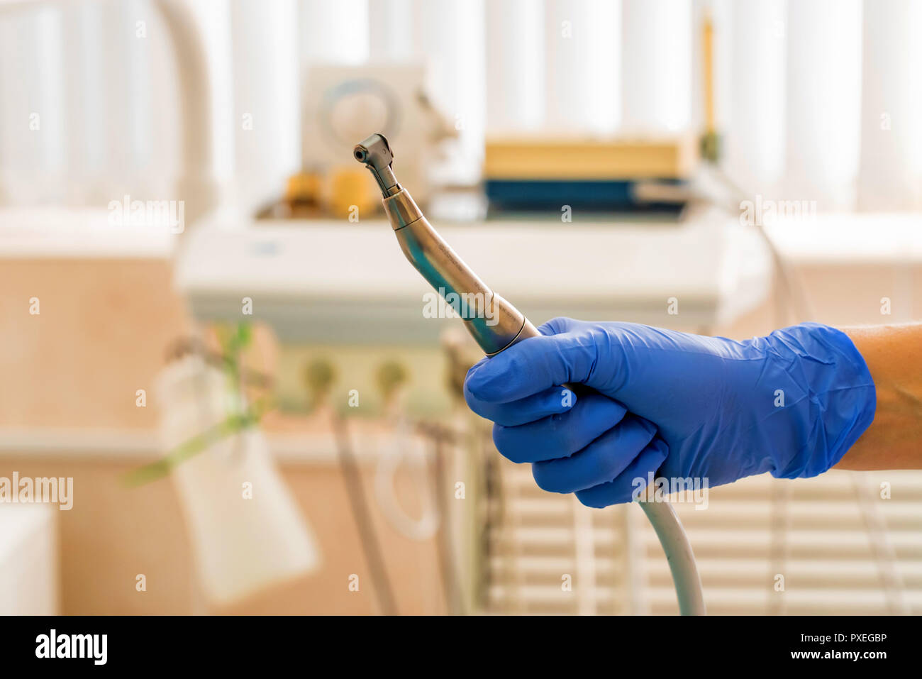Hand of dentist in glove holds dental drill machine Stock Photo Alamy