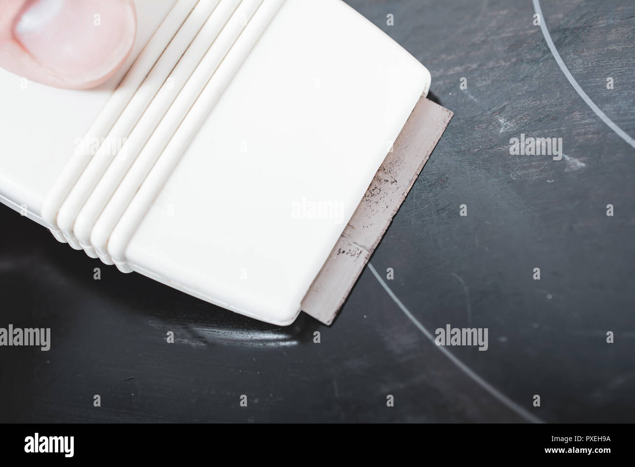 Cleaning A Ceramic Glass Cooktop With A Glass Scraper Stock Photo