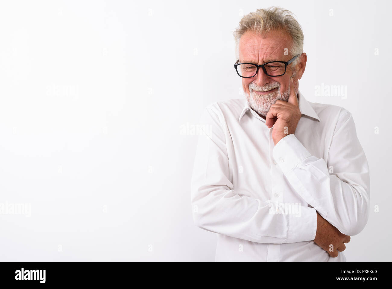 Studio shot of sad senior bearded man thinking while crying with Stock Photo