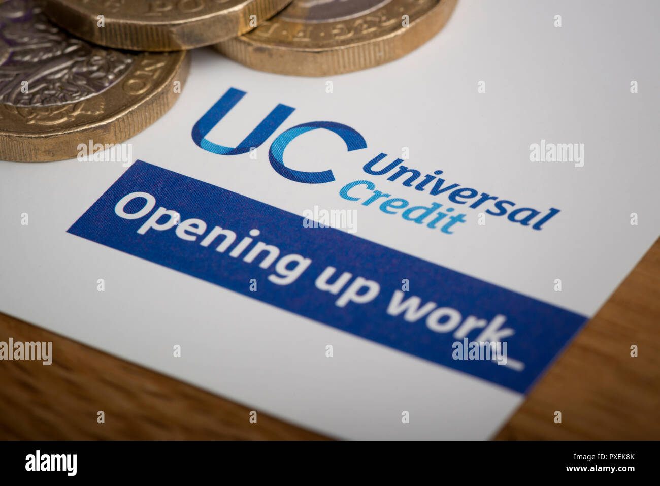 A piece of stationery featuring the Universal Credit logo, rests on a table along with some £1 coins. Stock Photo