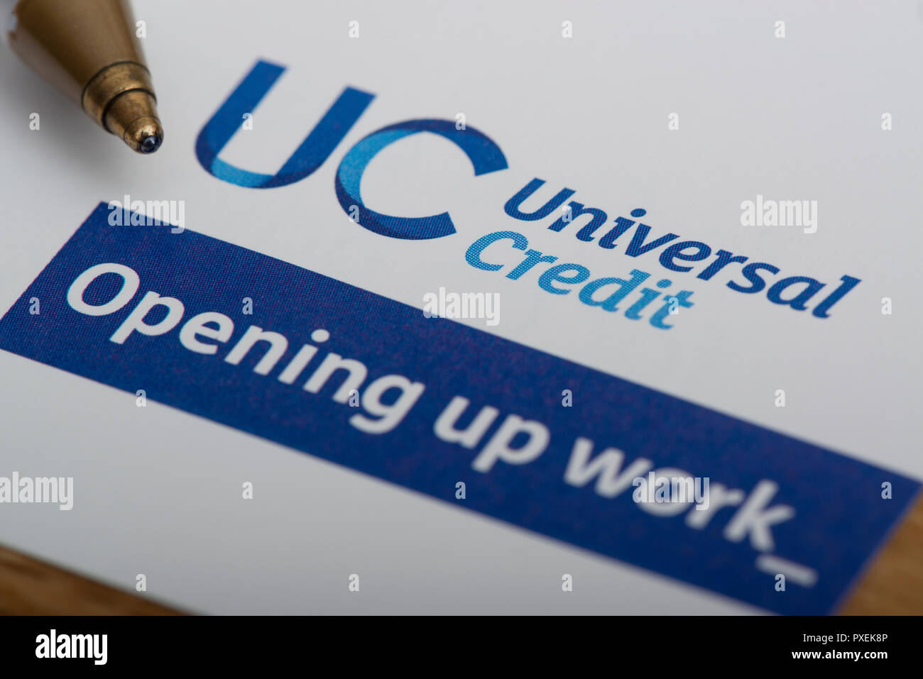 A piece of stationery featuring the Universal Credit logo, rests on a table along with a pen. Stock Photo