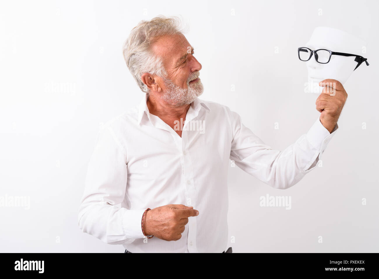 Profile view of happy senior bearded man smiling and looking at  Stock Photo