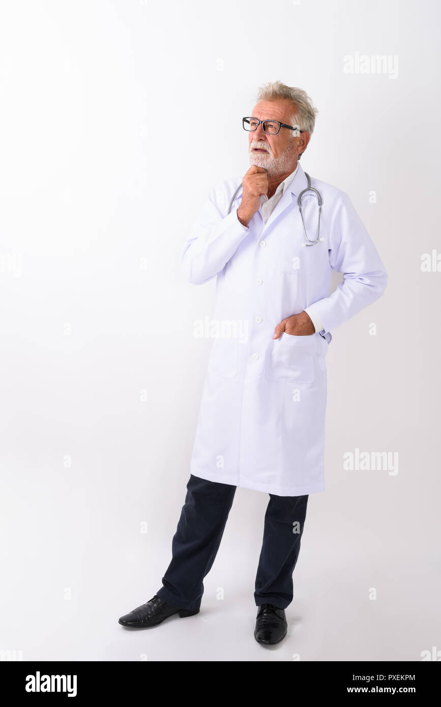 Full body shot of handsome senior bearded man doctor standing an Stock Photo