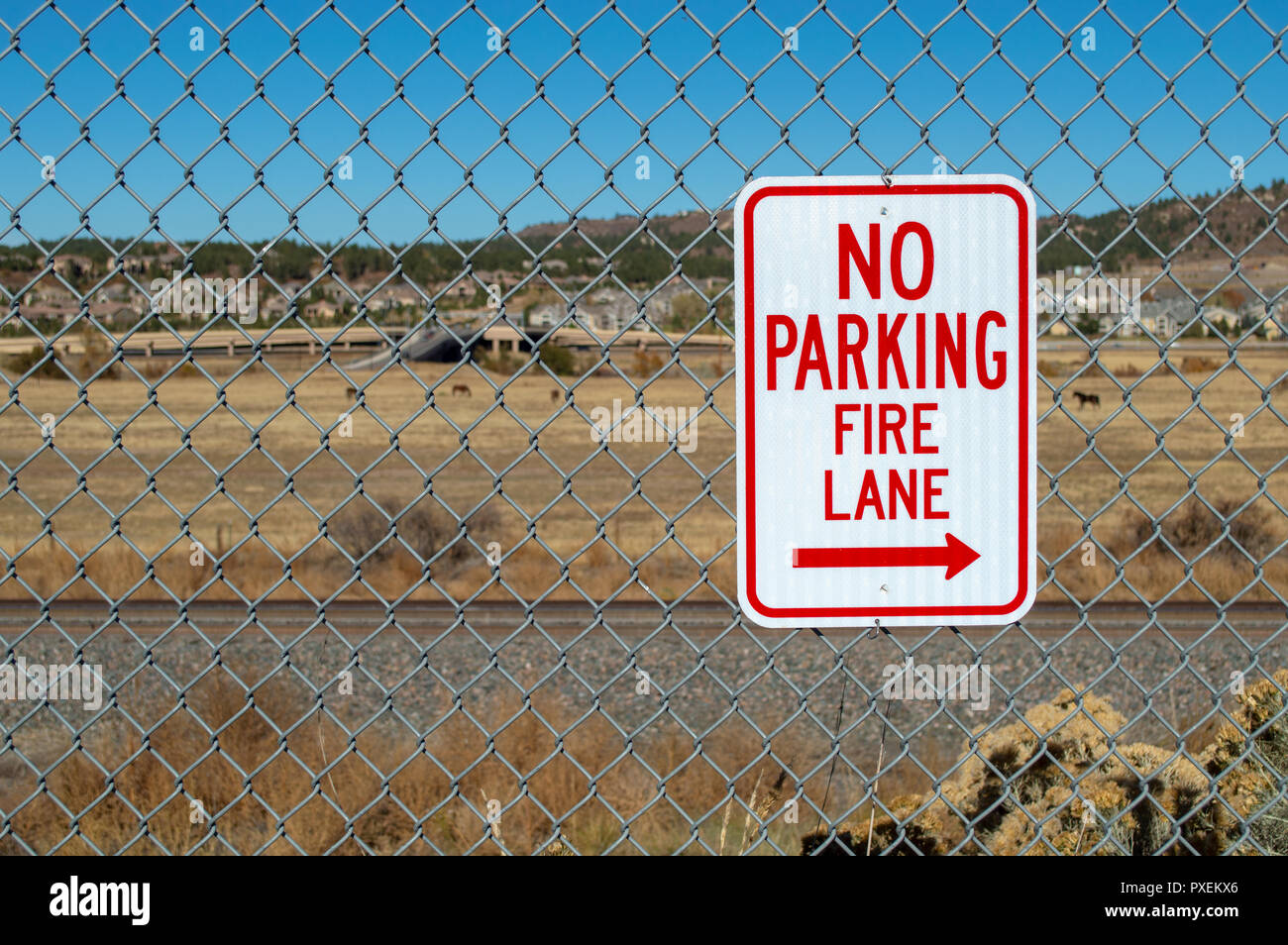 No parking fire lane sign on fence in parking lot Stock Photo