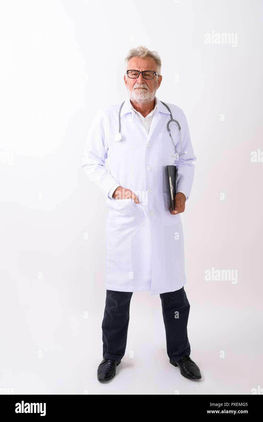 Full body shot of handsome senior bearded man doctor standing wh Stock Photo