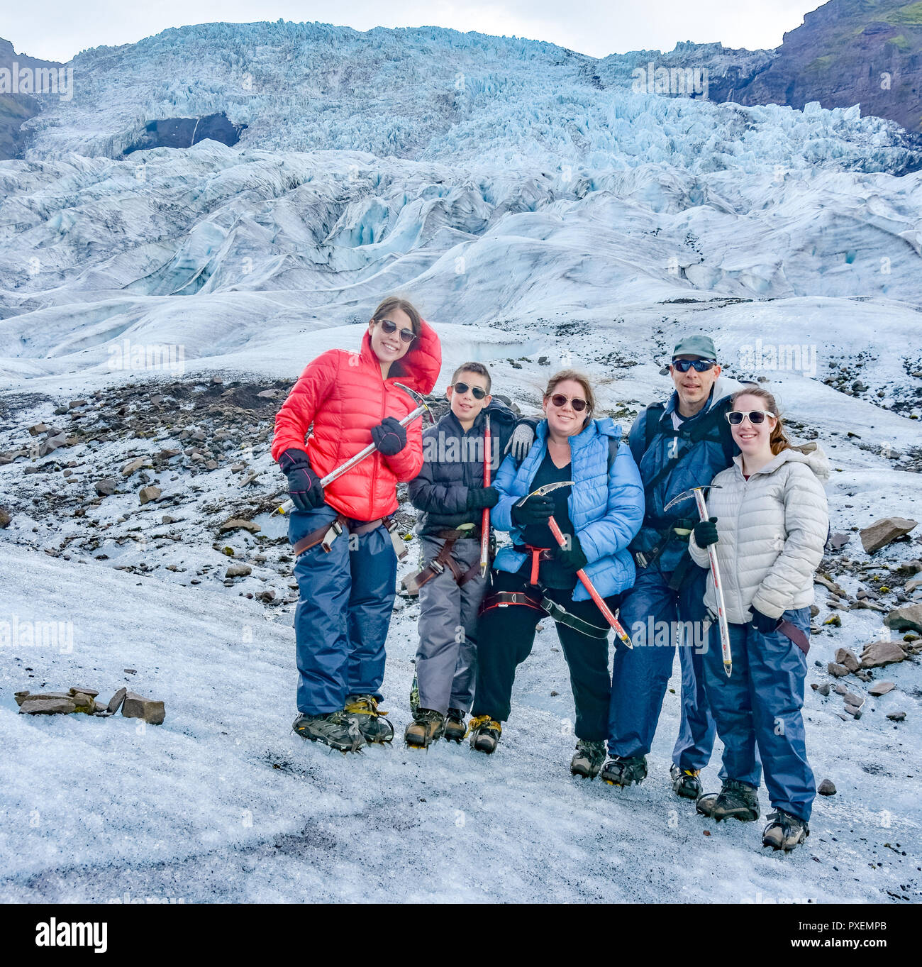 Family having fun  holding anice axes on a blue ice tour on the amazing Vatnajokull glacier in South Iceland Stock Photo