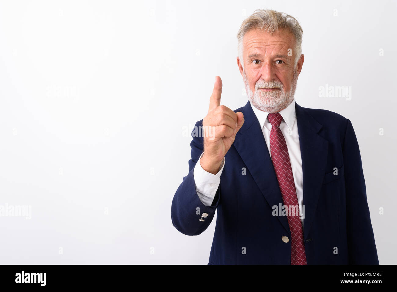 Studio shot of handsome senior bearded businessman pointing fing Stock Photo