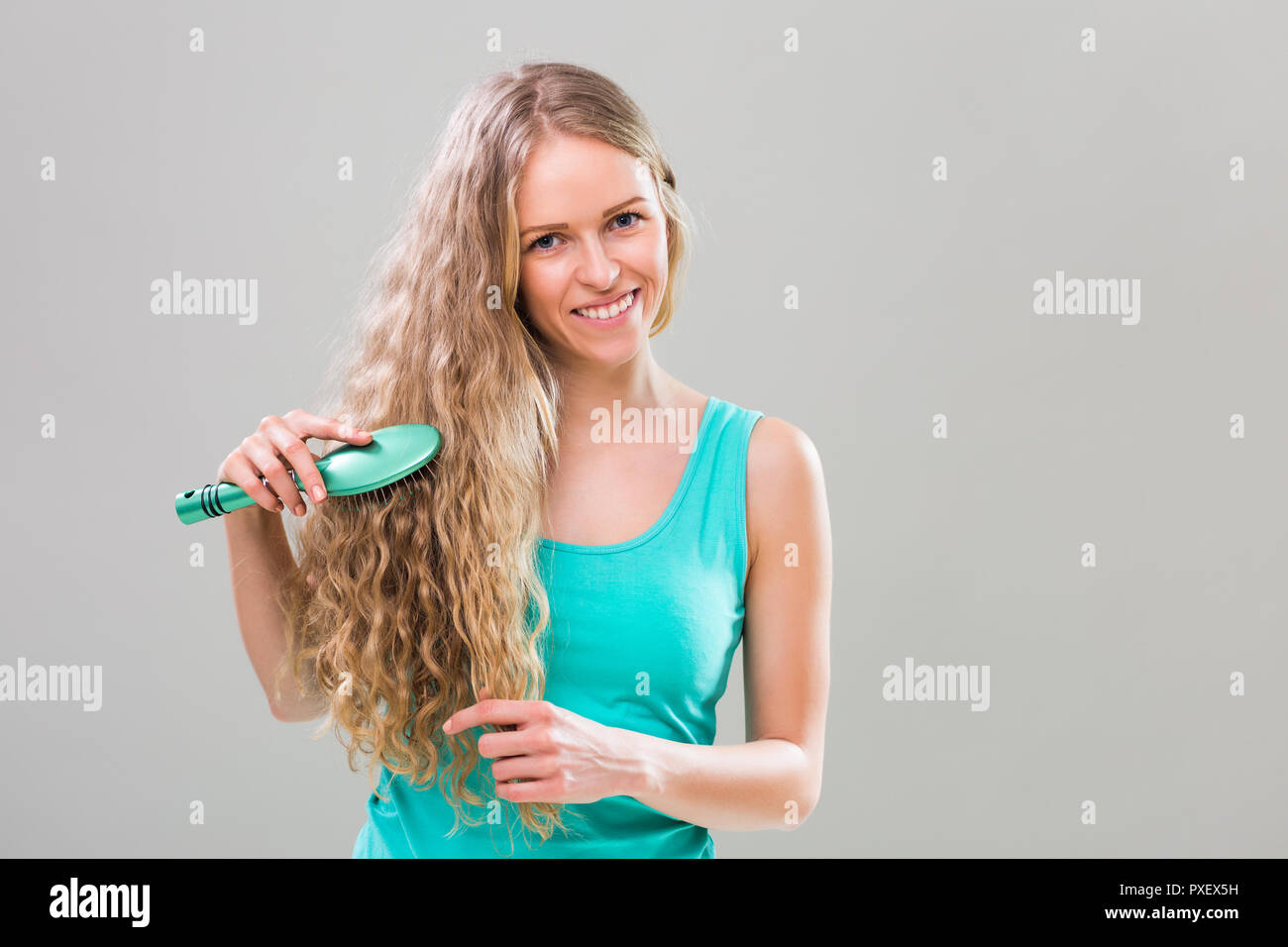 Young woman brushing her long blonde hair Stock Photo Alamy