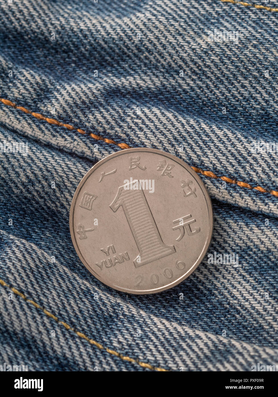 Chinese Yuan / Renminbi coin with pocket - metaphor for personal earnings, Chinese wages, wage levels, China garment industry. Stock Photo