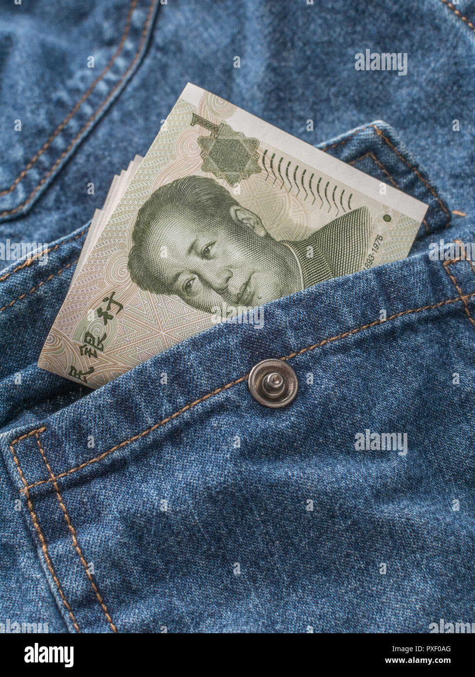 Chinese Yuan / Renminbi banknotes with pocket - metaphor for personal earnings, Chinese wages, wage levels, China garment industry. Stock Photo