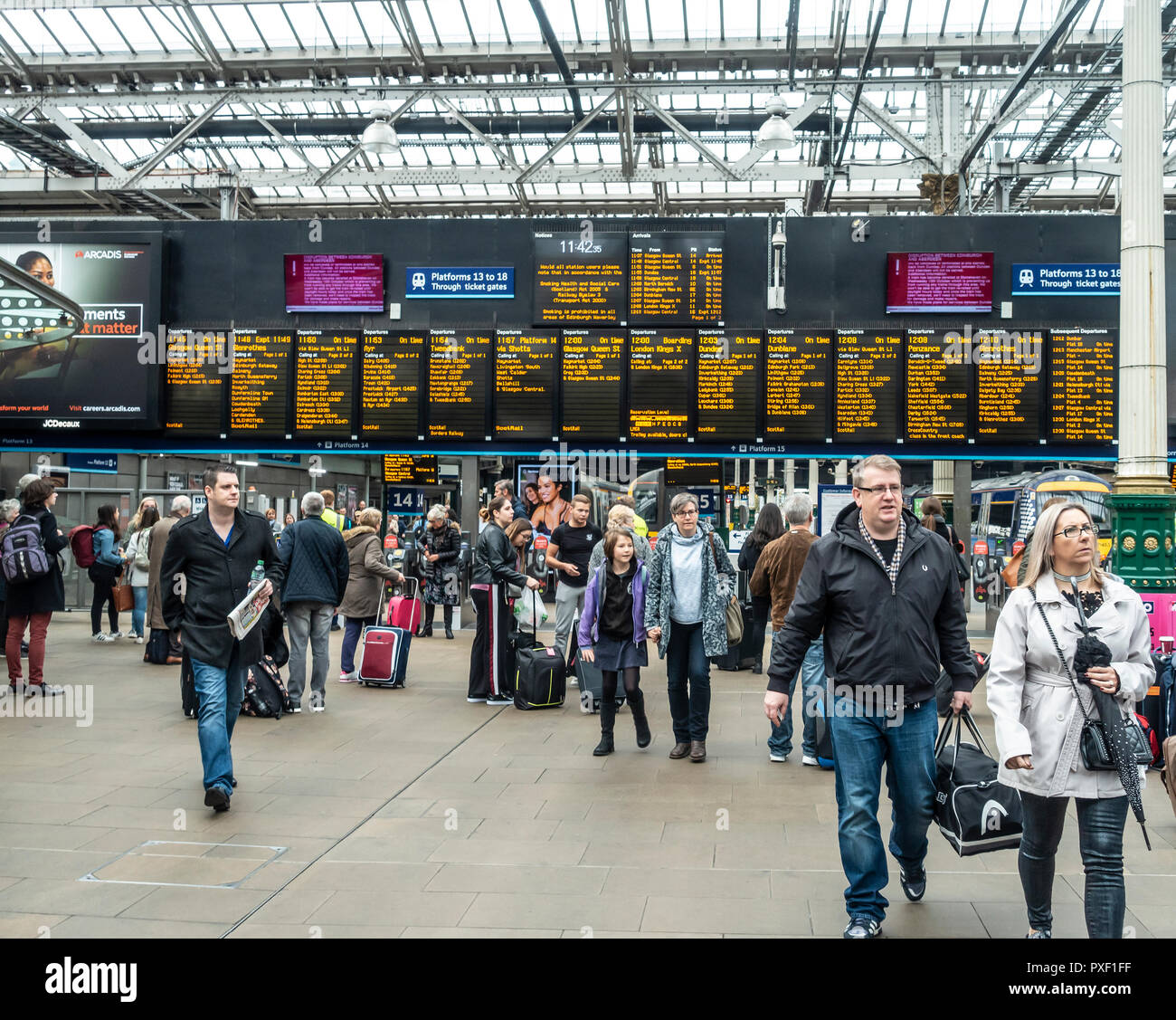 Passengers in the concourse in front of a departures board in Edinburgh