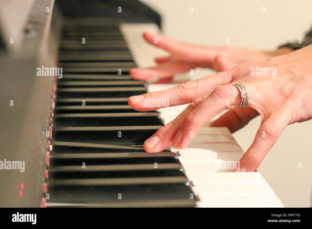 Woman playing piano with silver and diamond ring and a platinum ring next  to it Stock Photo - Alamy