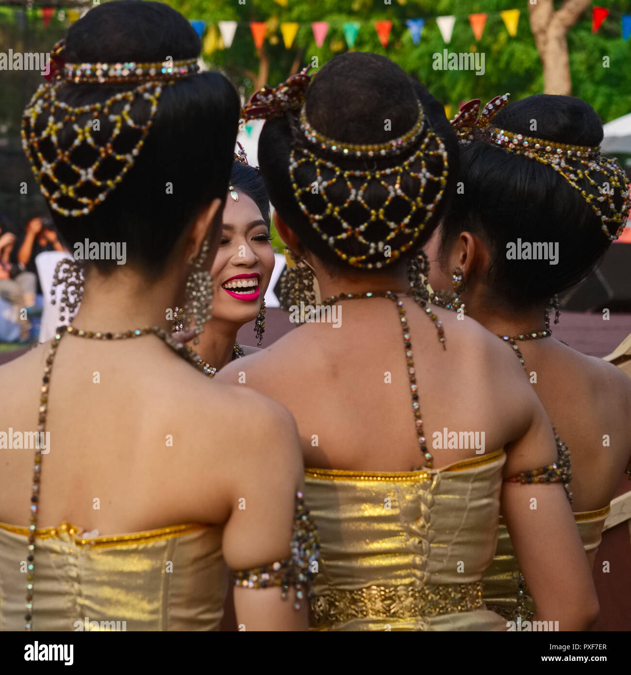 A group of Thai students backstage, shortly  before performing classical Thai dances, in Santichaiprakarn Park, Bangkok, Thailand Stock Photo