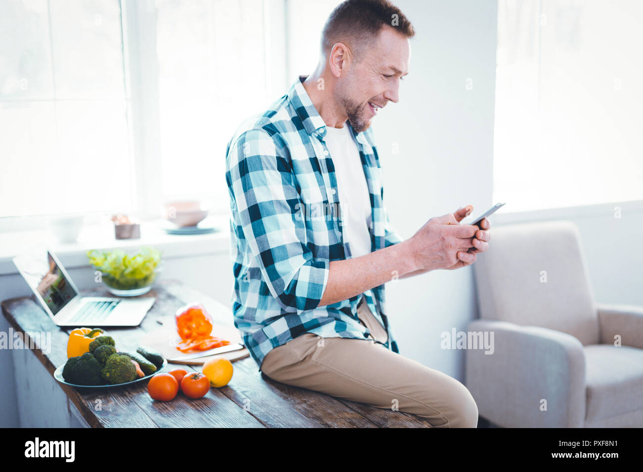 Joyful nice positive man using social media Stock Photo