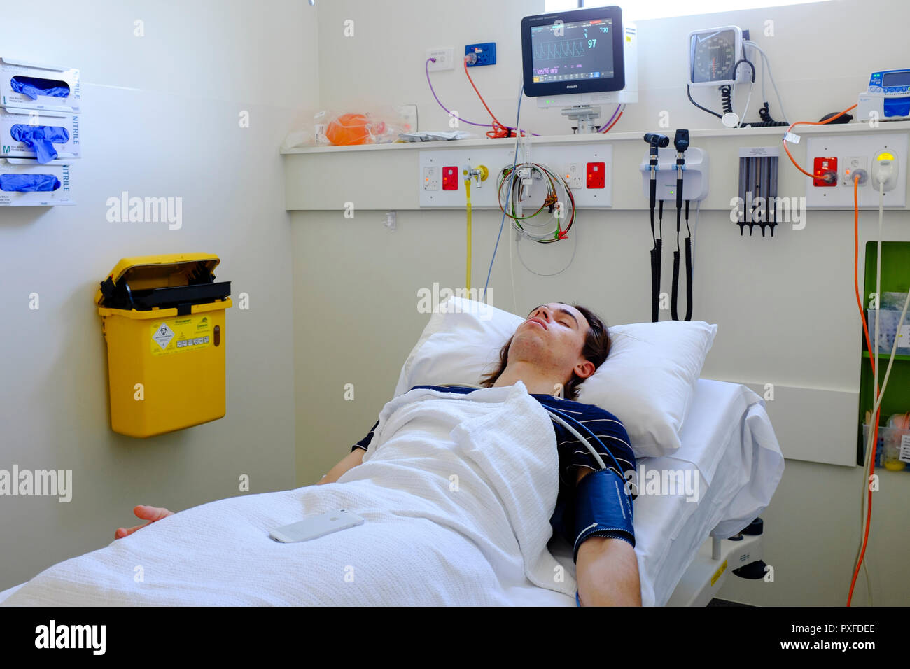 Patient, 19 year old young man, in bed in emergency department in hospital, Australia Oct 2018 Stock Photo