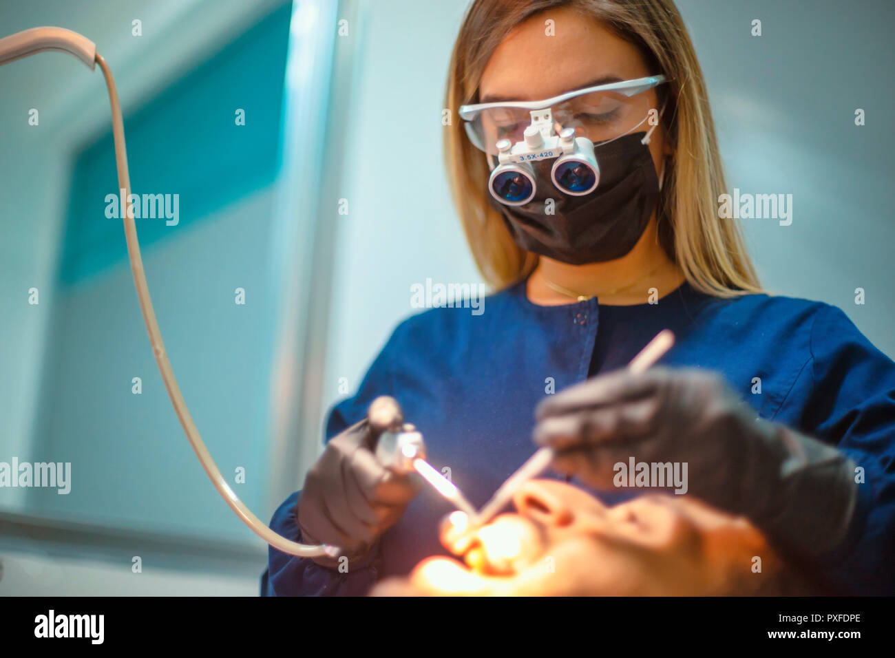 closeup young woman dentist working with magnifying glasses Stock