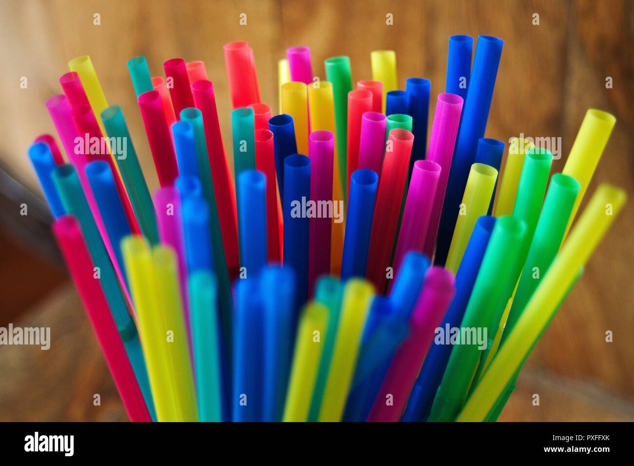 A collection of new plastic, disposable colored straws standing upright in a cup. Stock Photo