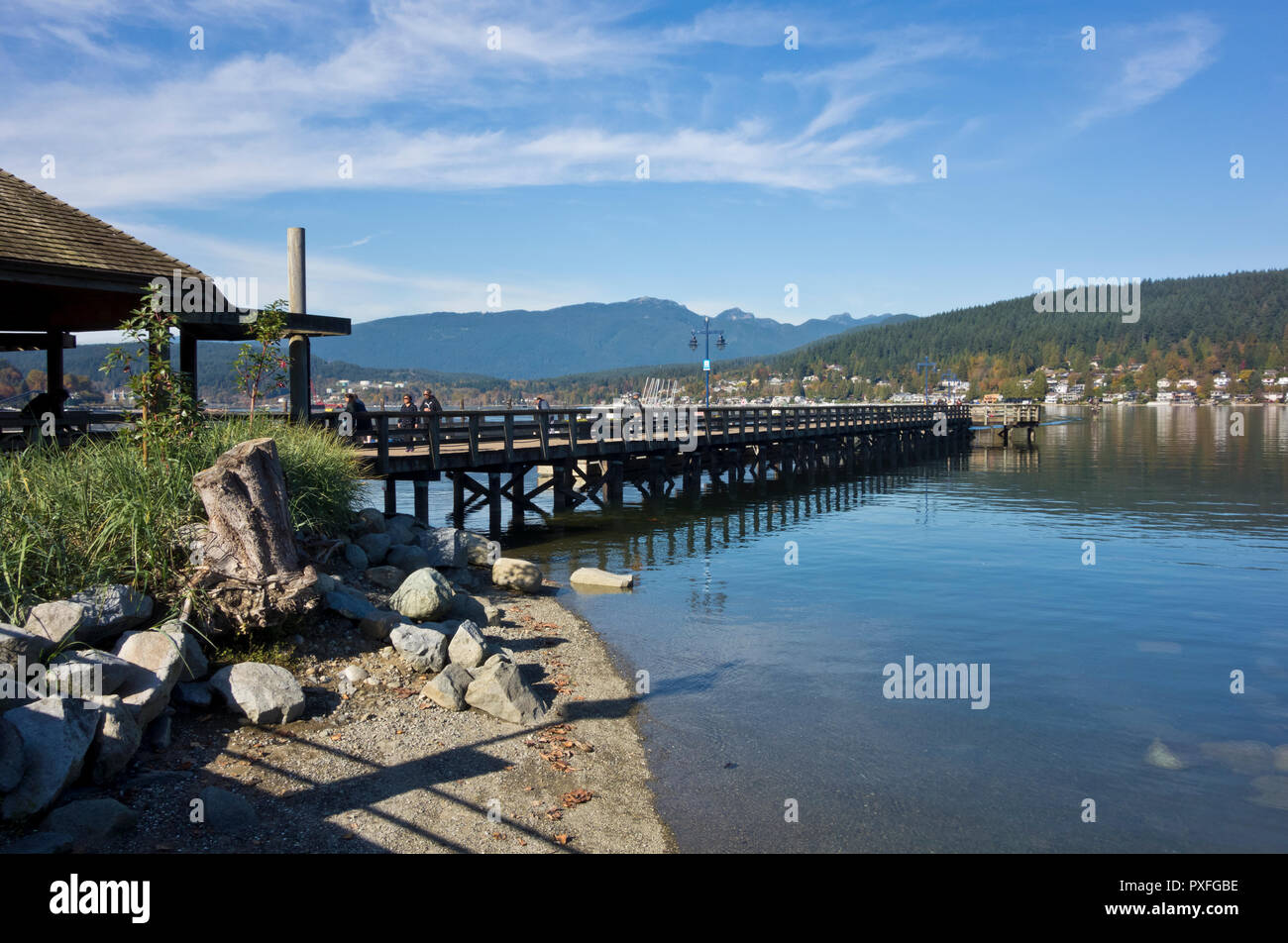 Pier at Rocky Point Park in Port Moody, BC, Canada on a sunny Autumn day.  Burrard Inlet and mountains, Metro Vancouver urban park. Stock Photo