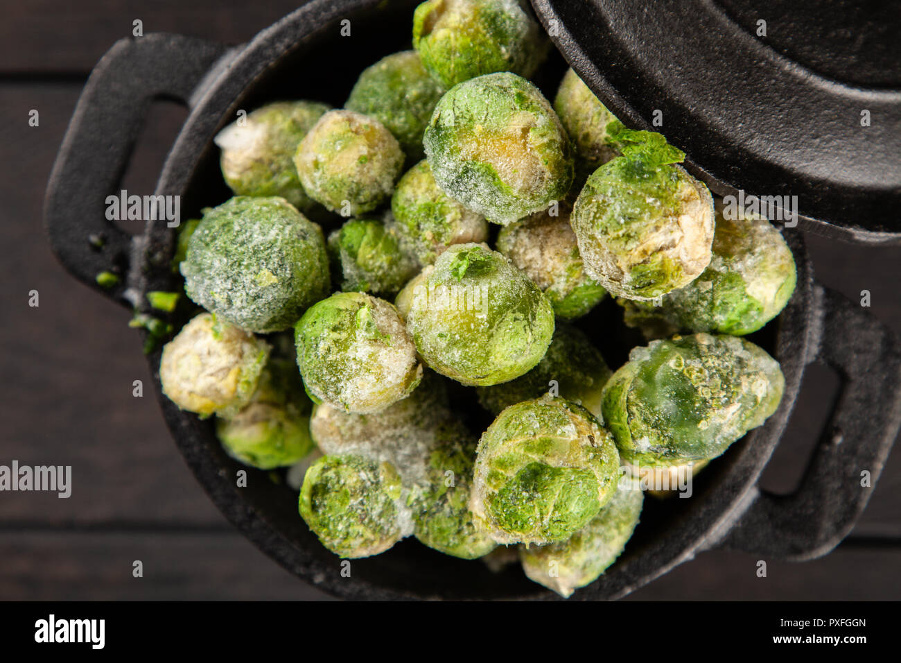 Frozen brussles sprouts on dark background Stock Photo