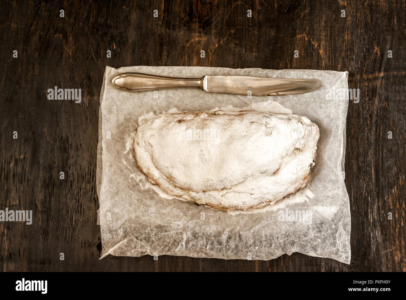 Traditional German Christmas fruit cake stollen on a dark background
