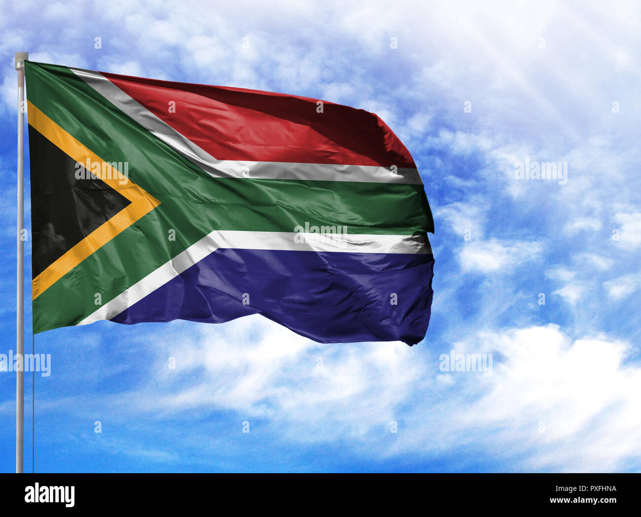 National flag of South Africa on a flagpole in front of blue sky Stock