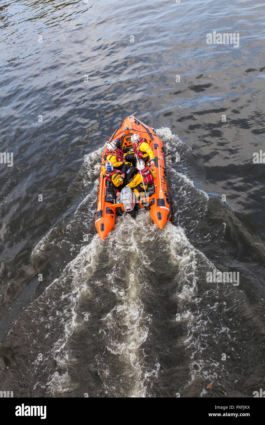 RNLI lifeboat crew on a training exercise in a dinghy at Teddington