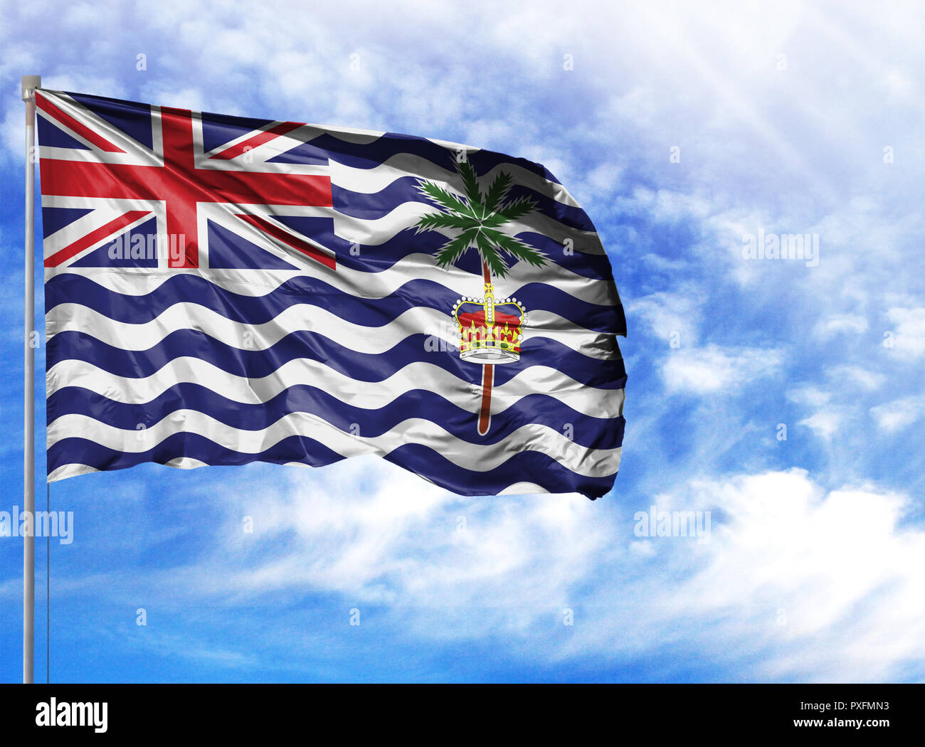 National flag of British Territory in the Indian Ocean on a flagpole in front of blue sky. Stock Photo