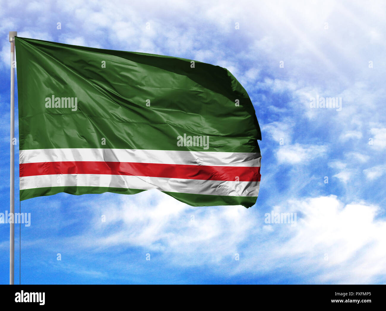 National flag of Chechen Republic of Ichkeria on a flagpole in front of blue sky. Stock Photo