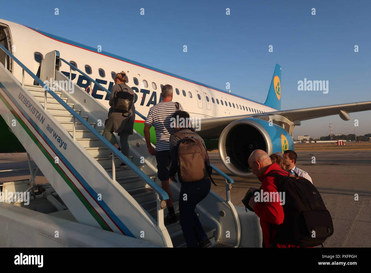 Passengers embark an airplane of National Air Company Uzbekistan Airways at Tashkent Yuzhny International Airport Uzbekistan Stock Photo