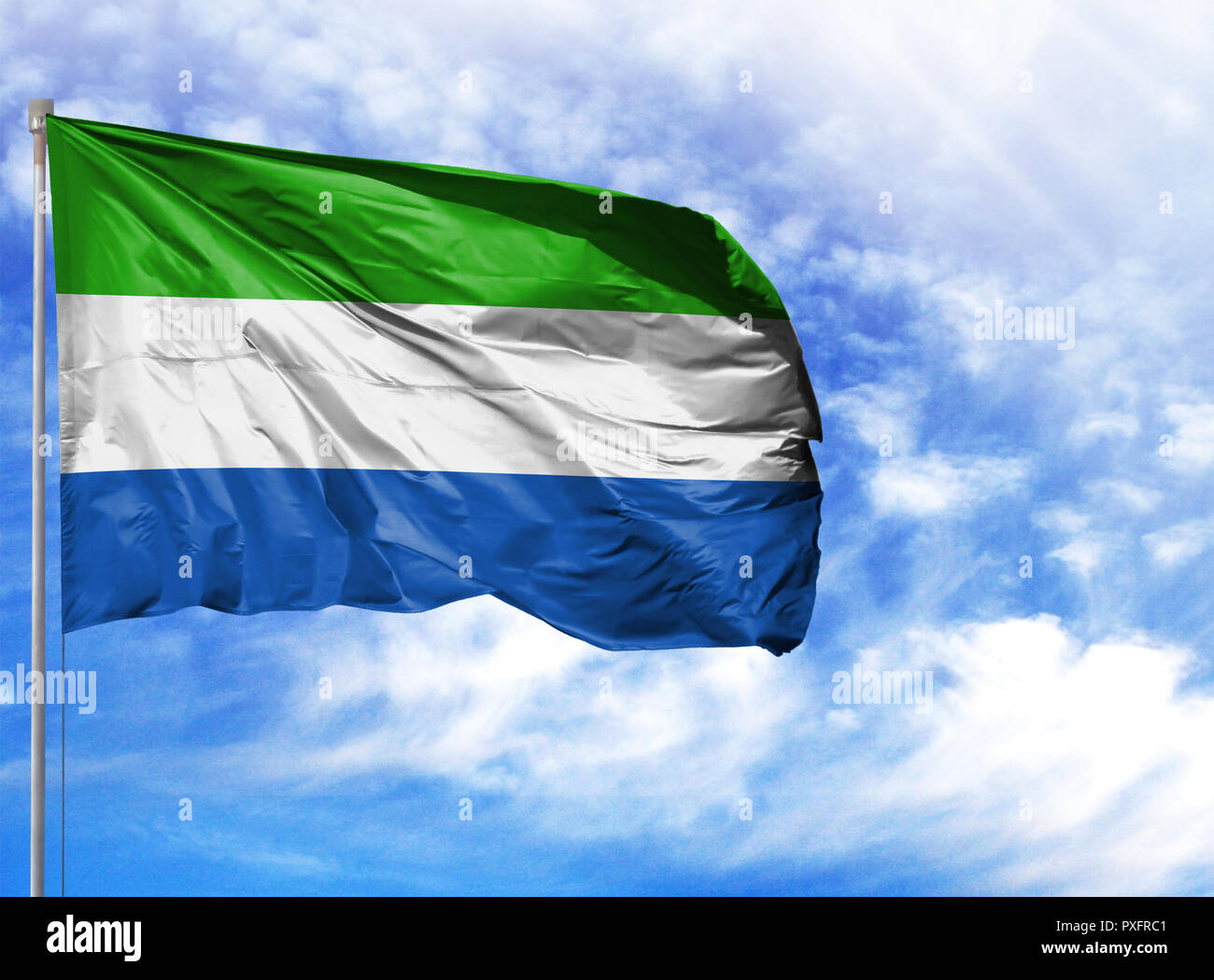 National flag of Sierra Leone on a flagpole in front of blue sky Stock ...