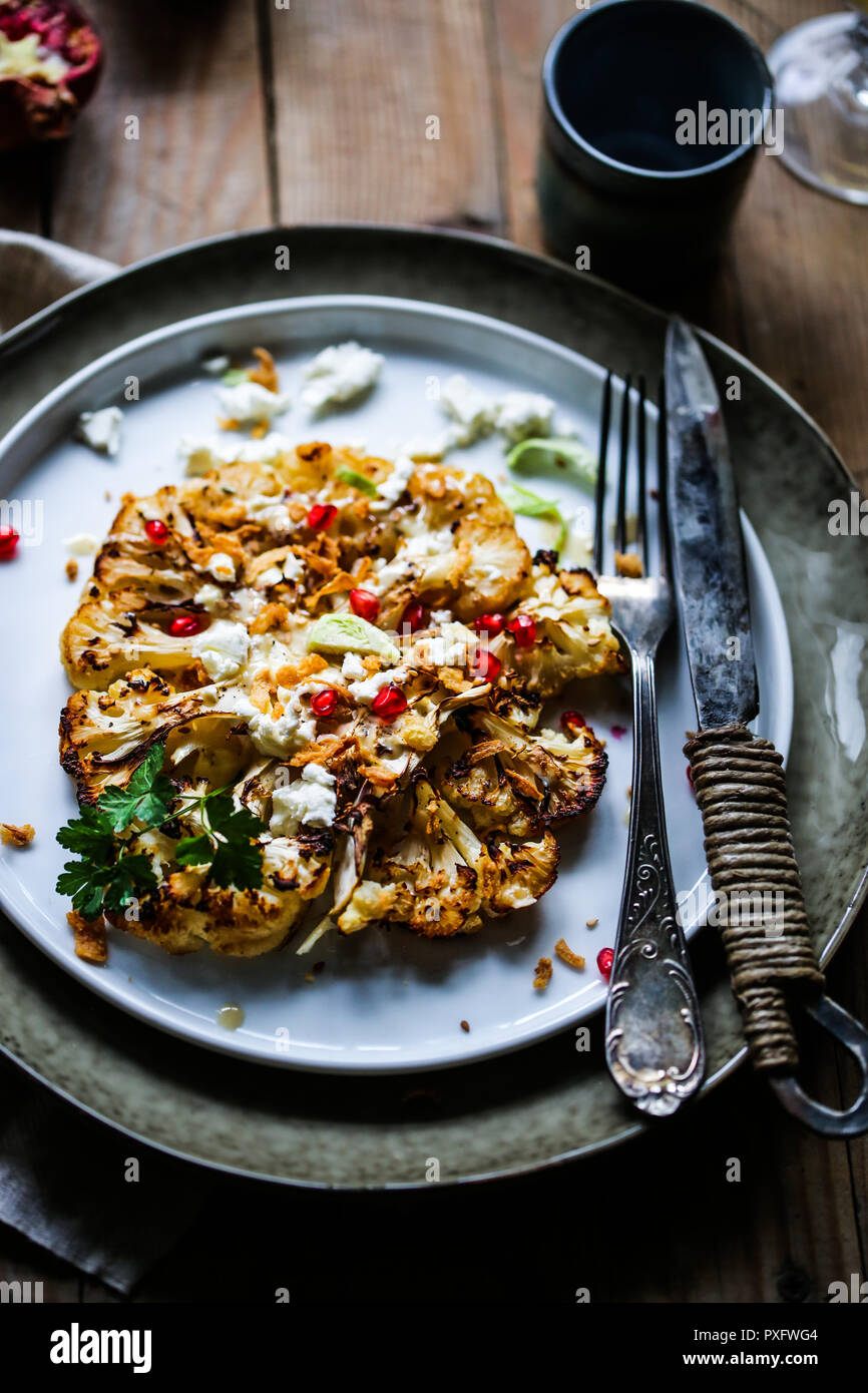 Roasted cauliflower steak with tahini sauce, feta cheese and pomegranate Stock Photo Alamy