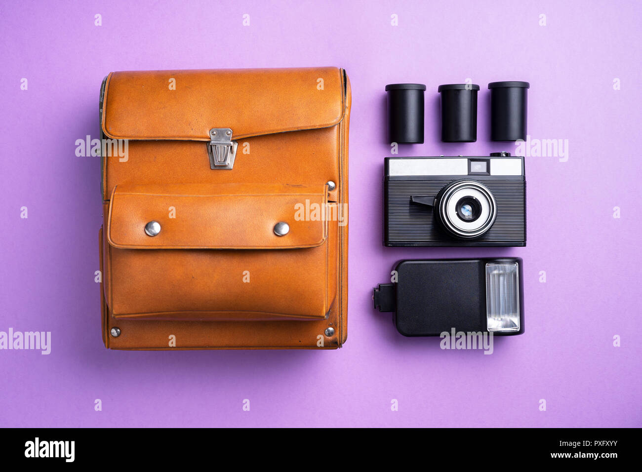 Analog camera and other accessories over purple background Stock Photo
