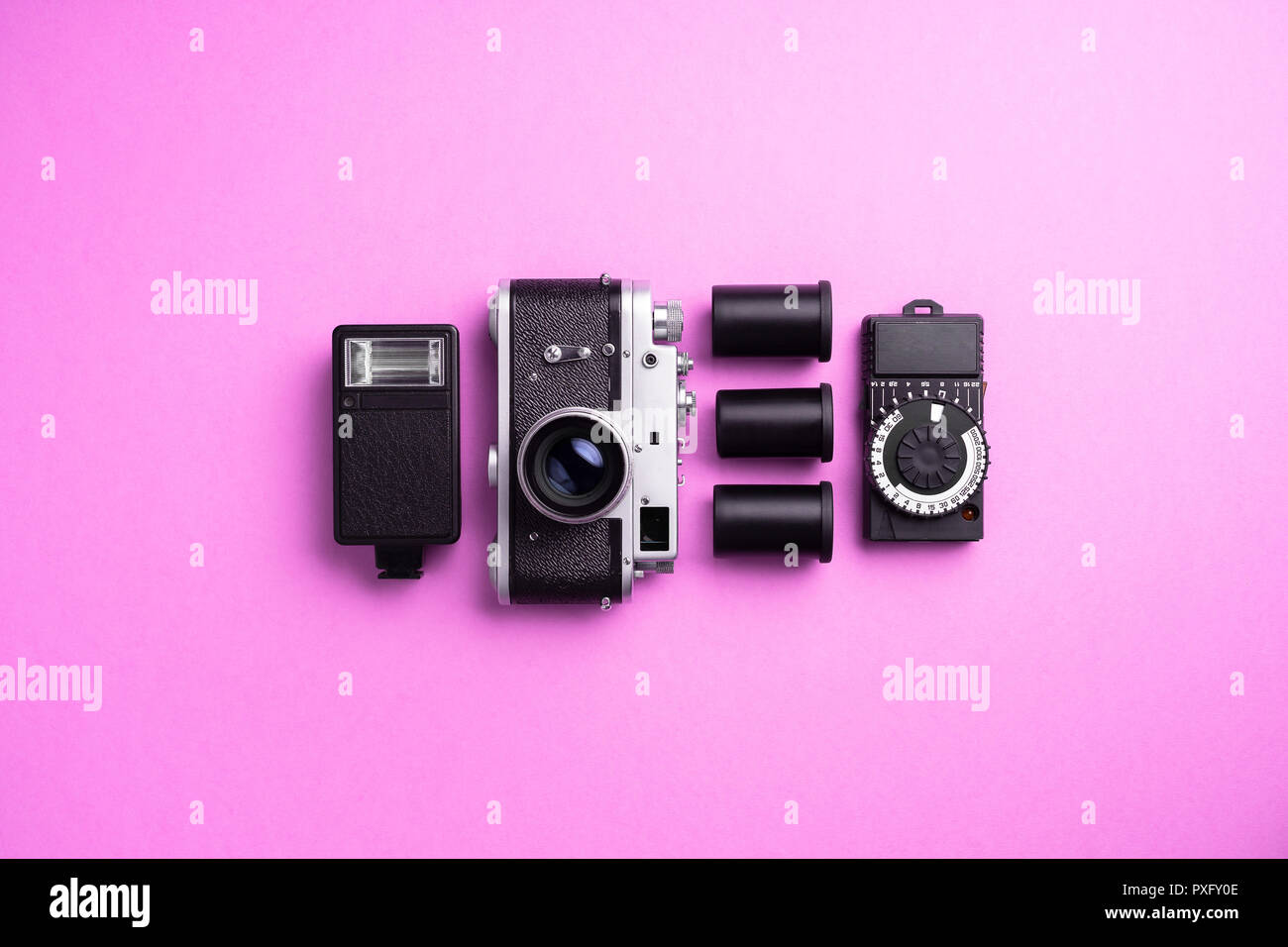 Analog camera and other accessories over pink background Stock Photo