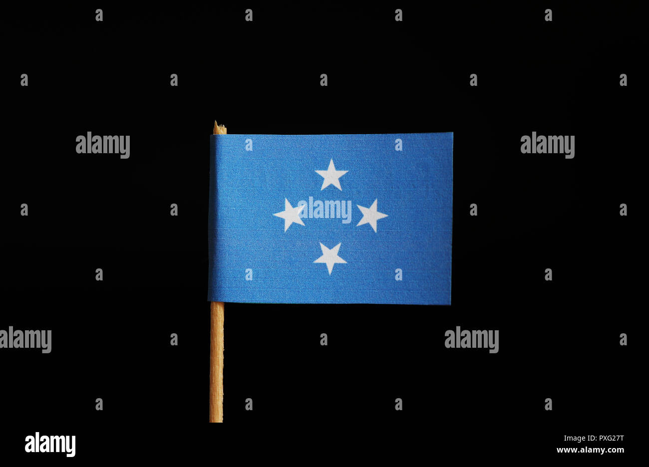 A national flag of Federated States of Micronesia on wooden stick on black background. The federation belongs to Oceania. Group of islands. Stock Photo