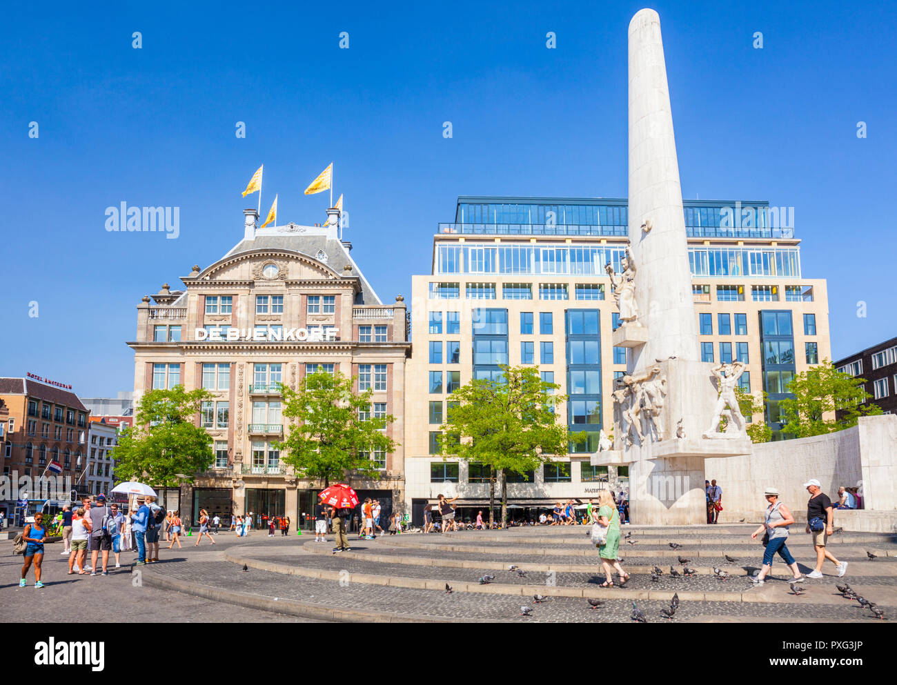 Amsterdam Dam Square National Monument to WW2 war memorial  and the de Bijenkorf shopping mall Amsterdam The Netherlands Holland EUROPE EU Stock Photo