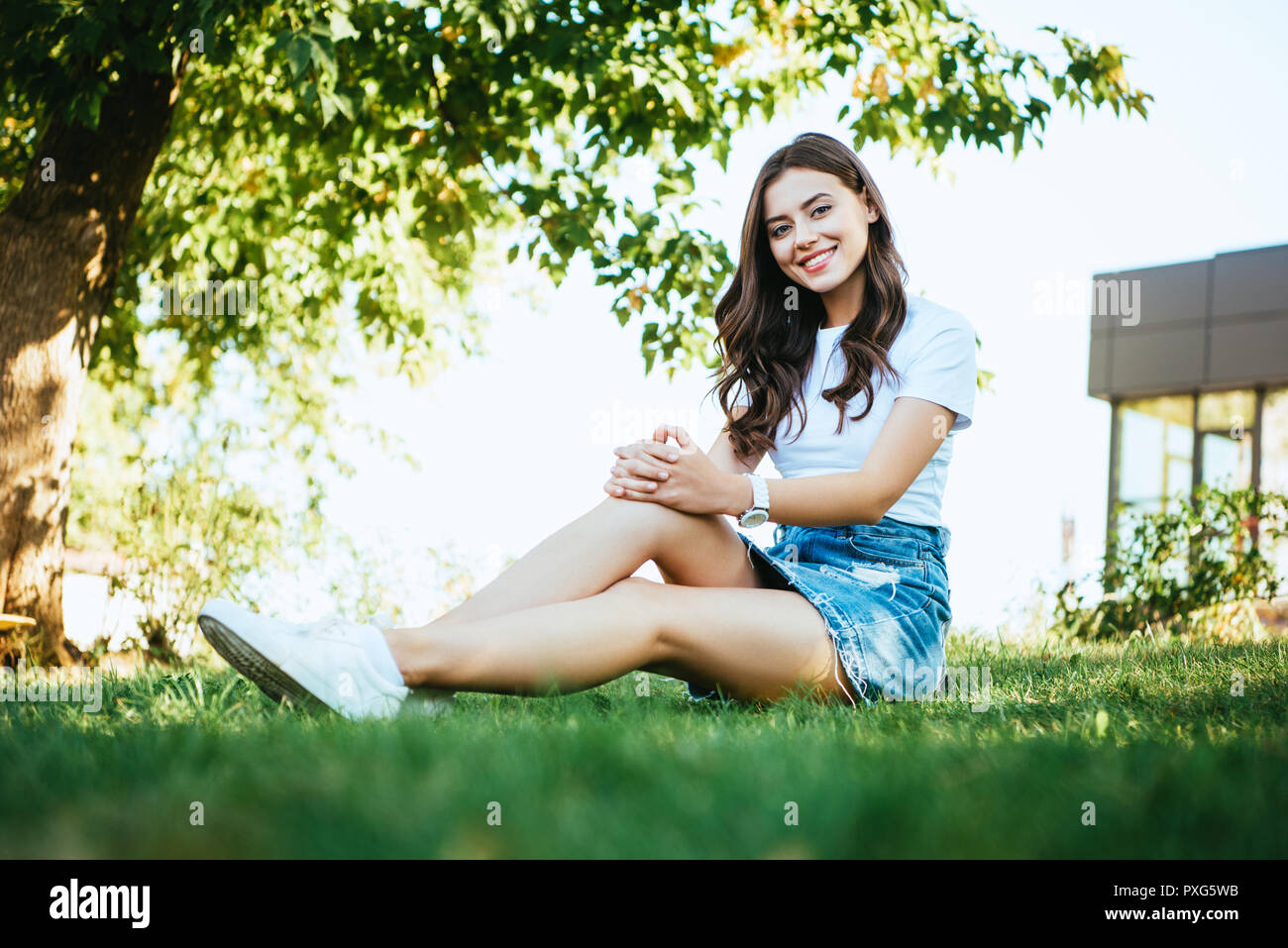 A Young Blonde Is Sitting In A Clearing. Green Grass. A Girl Poses In A  Meadow. Stock Photo, Picture and Royalty Free Image. Image 148907542.