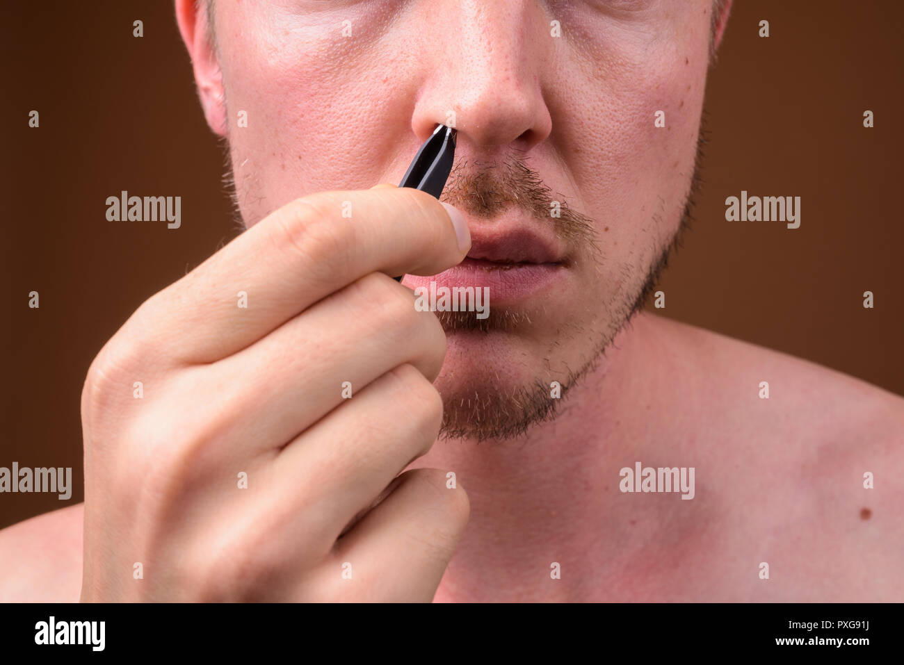 Man Picking Up And Removing His Nose Hair Stock Photo 222863806