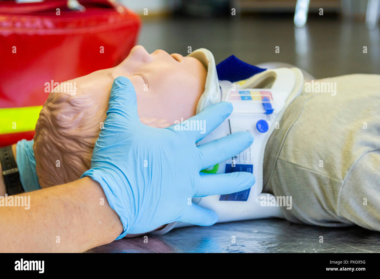 Human hands stabilisations the neck from a medical training puppet for ambulance man Stock Photo