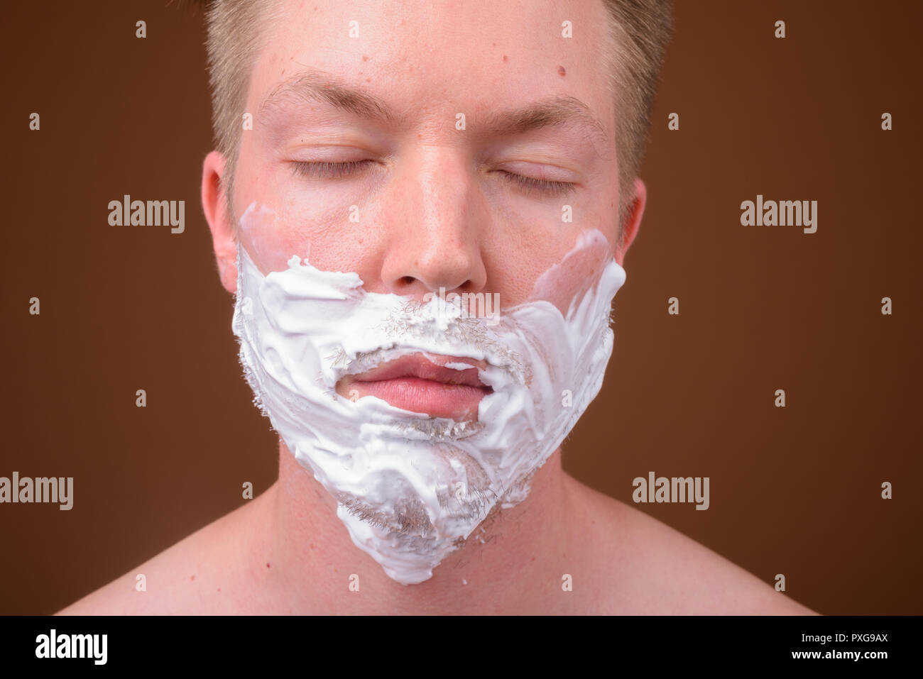 Face of young man shaving his face with eyes closed Stock Photo Alamy